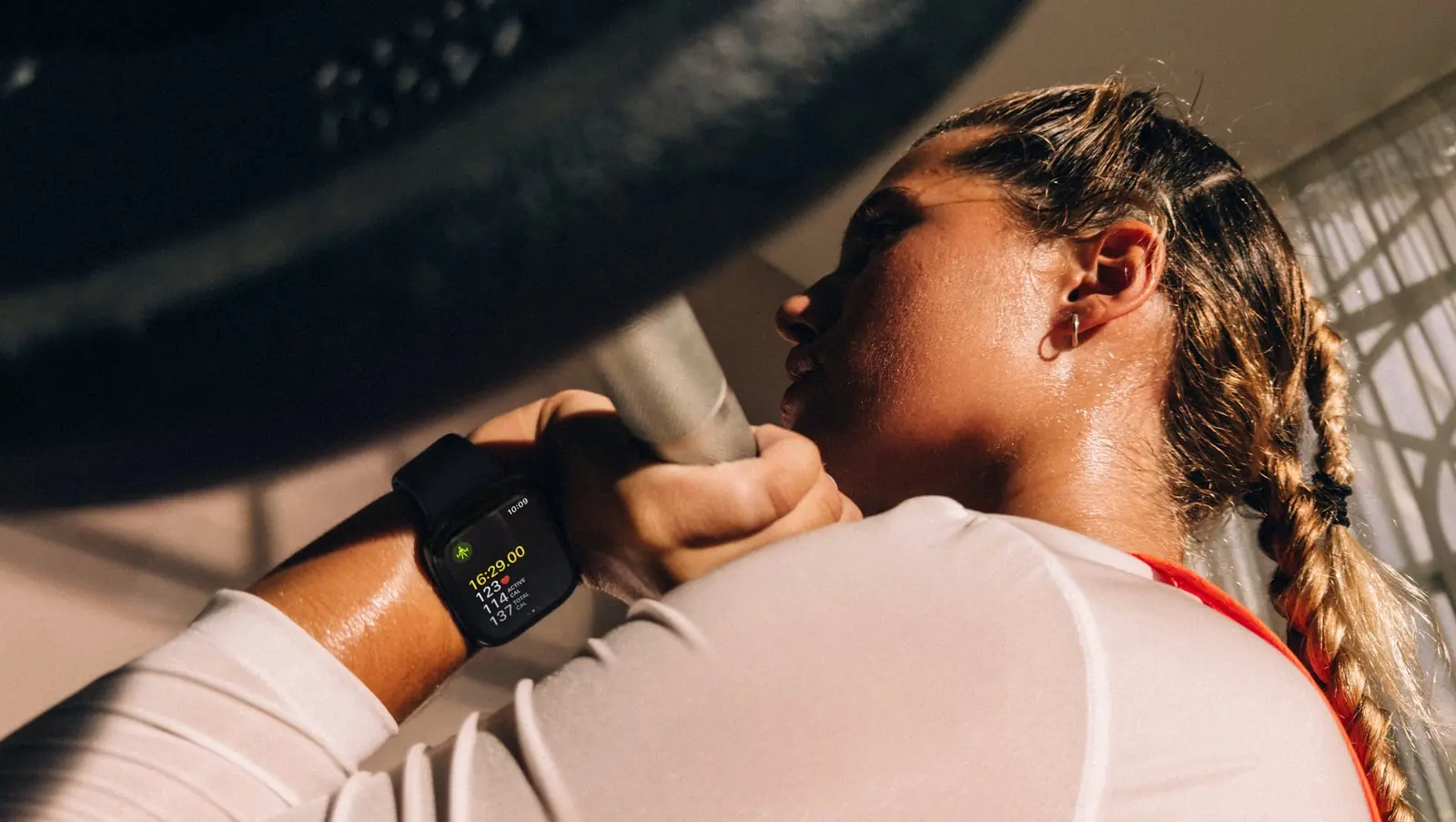 Žena při silovém tréninku s Apple Watch na zápěstí